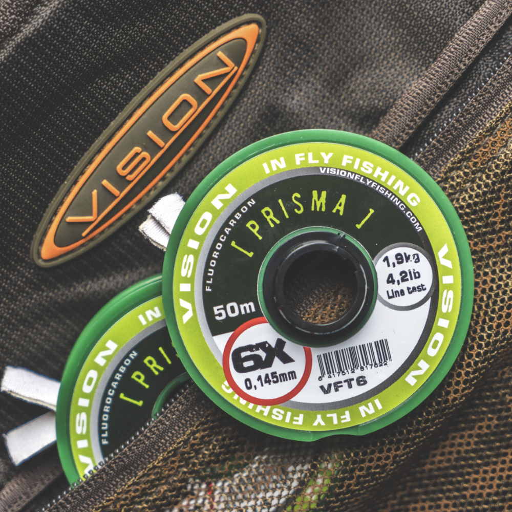 Vision Prisma FL Carbon Tippet Spule 4X, Vision Prisma FL Carbon Tippet 5X Fluorocarbon, Vision Prisma FL Carbon Tippet 6X feines Vorfachmaterial, Vision Prisma FL Carbon Tippet 7X für heikle Forellen, Detailaufsicht Prisma FL Carbon Tippet Beschriftung, Nahaufnahme Fluorocarbon Vorfach Vision Prisma, Prisma FL Carbon Tippet Spulen farbcodiert verbunden, Fliegenfischer nutzt Vision Prisma FL Carbon Tippet am Bergbach